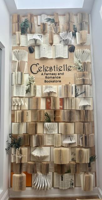 The Celestielle book wall, with the logo set among fanned-open books